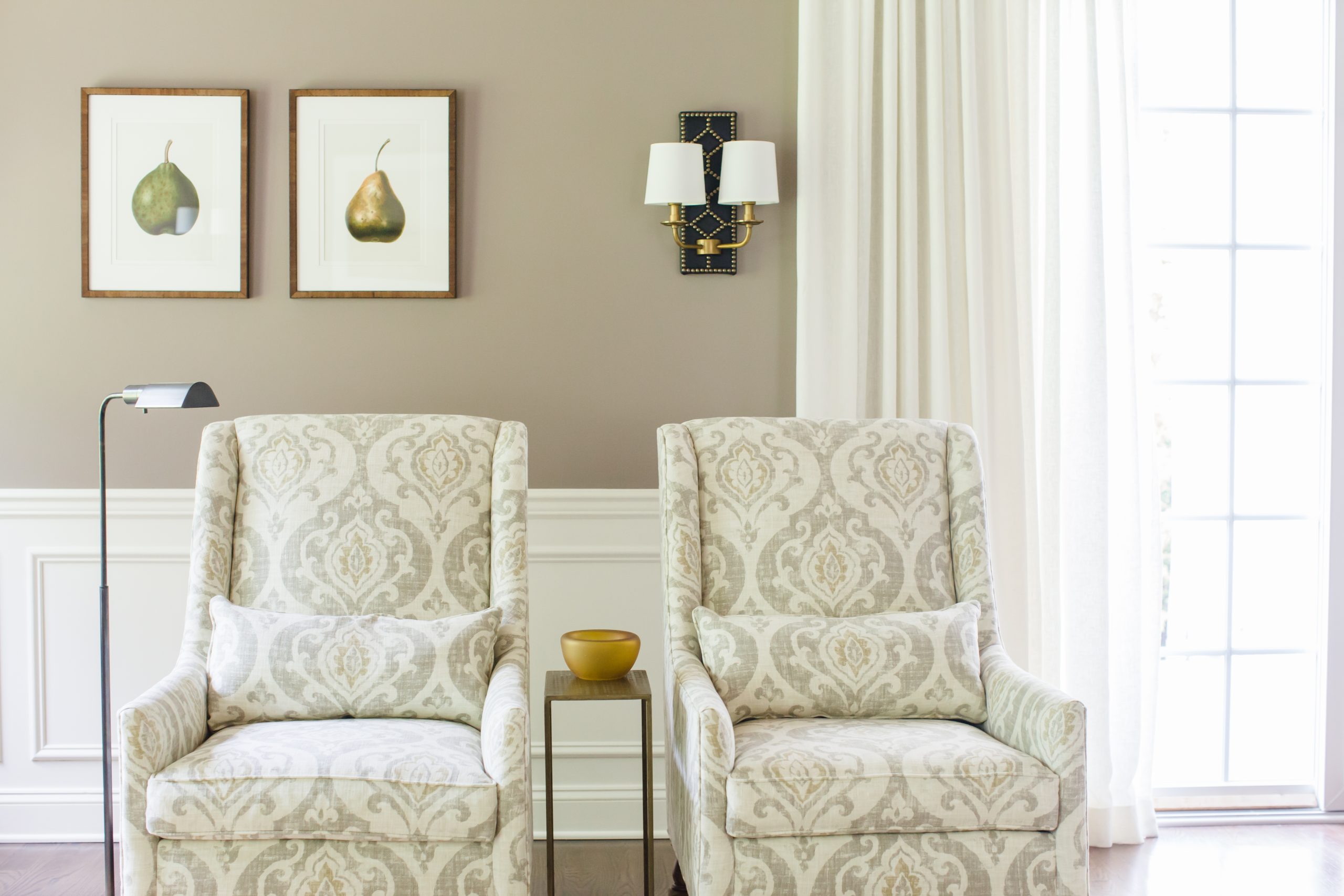 Decorative twin light cream armchairs with small wooden side table and stainless steel reading lamp