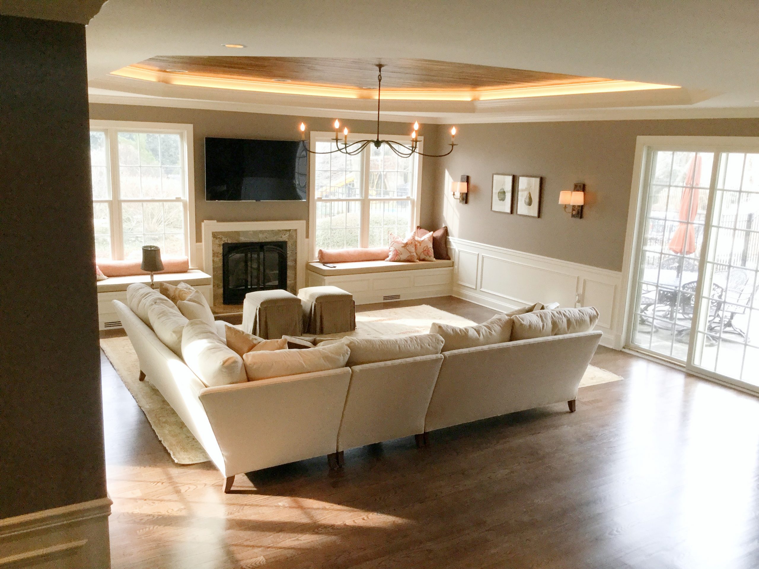Transitional family room with black metal chandelier, hardwood ceiling and beige furniture (Back corner)