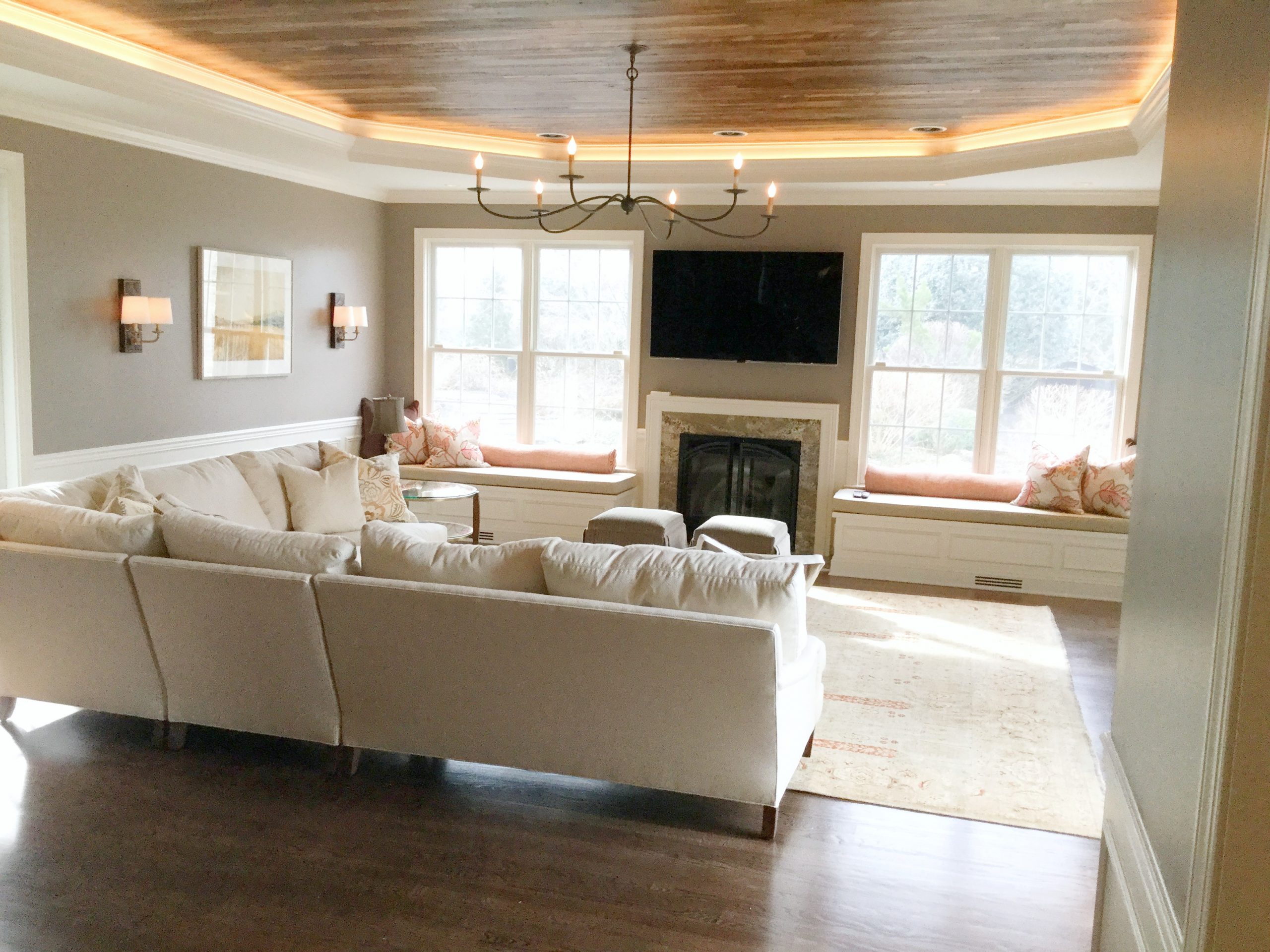 Transitional family room with black metal chandelier, hardwood ceiling and beige furniture