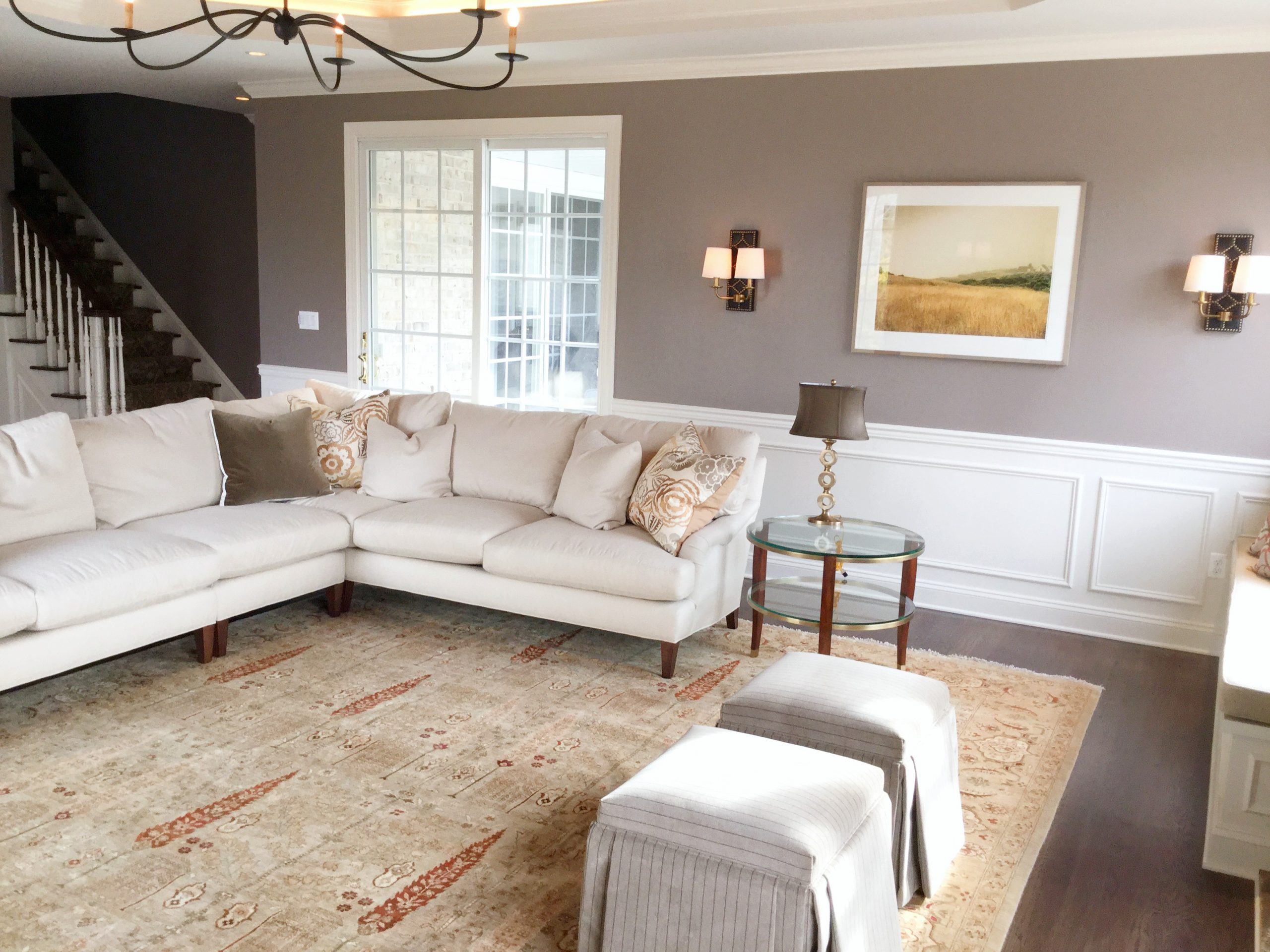 Transitional family room with dark hardwood flooring, patterned beige carpet, grey wall color, and minimal light beige furniture