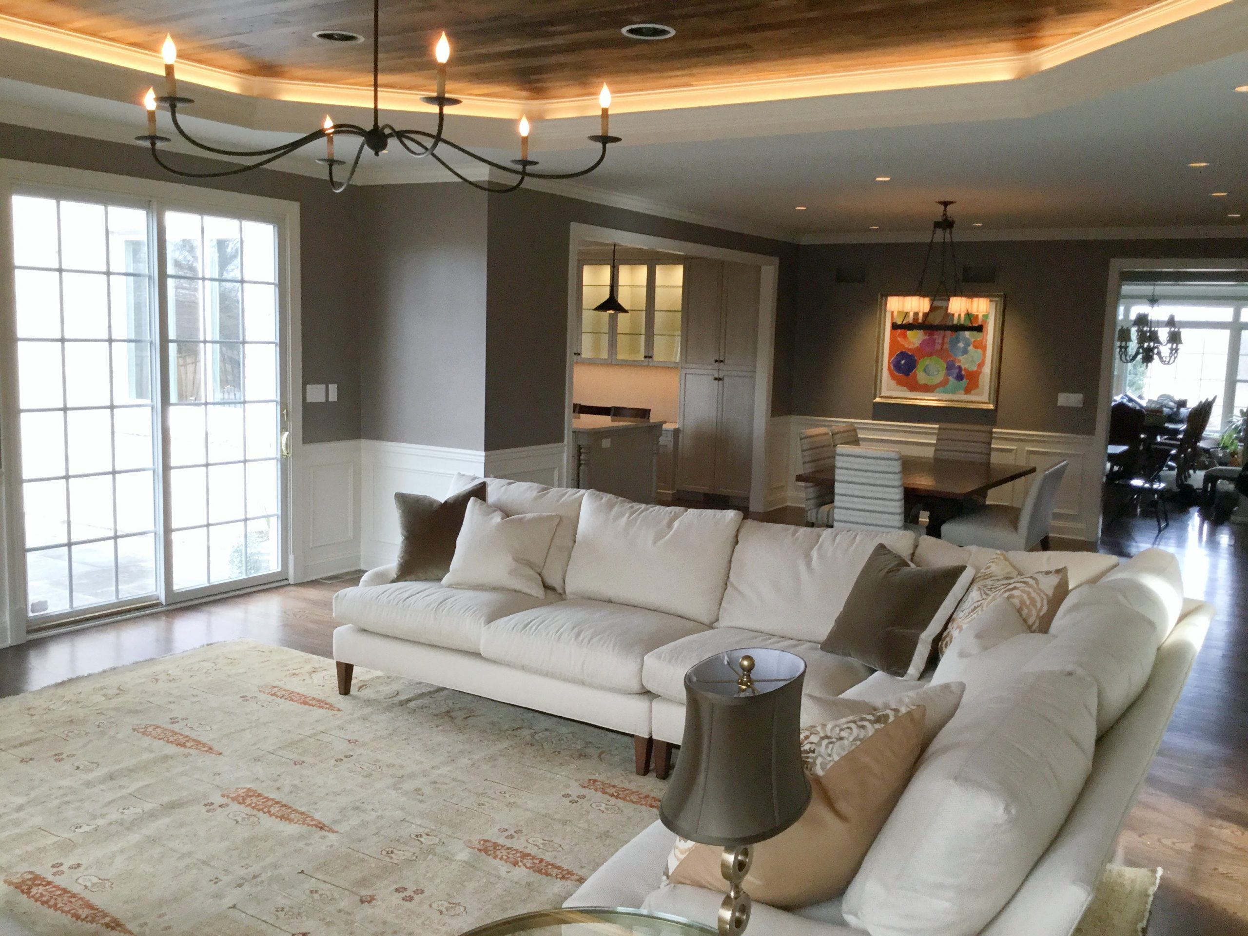 Transitional family and dining room with black metal chandelier and beige furniture