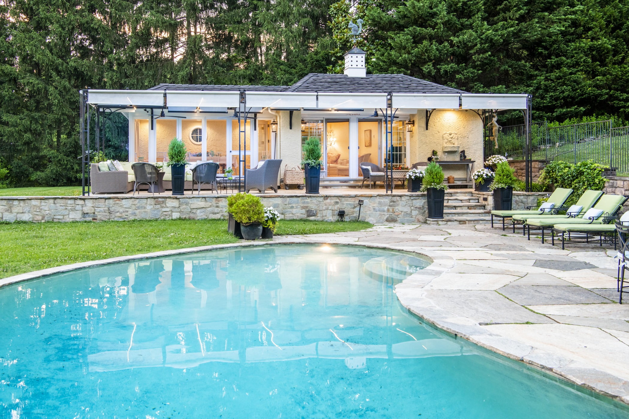 Luxury pool house custom designed for a home remodel with a large seating space and large metal pergola (Pool view)