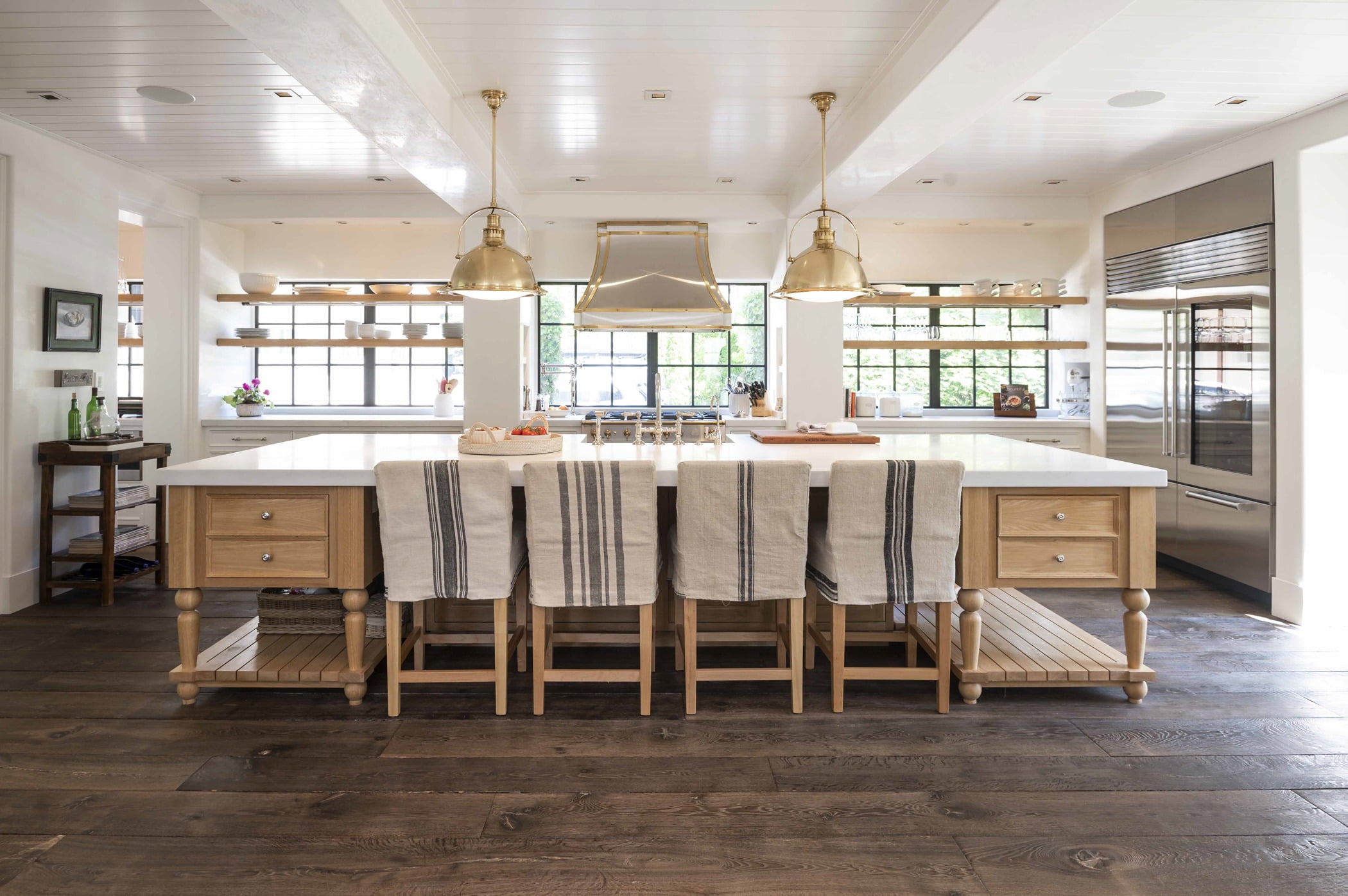 Transitional kitchen island with light wood cabinetry, white marble countertops and dark hardwood flooring