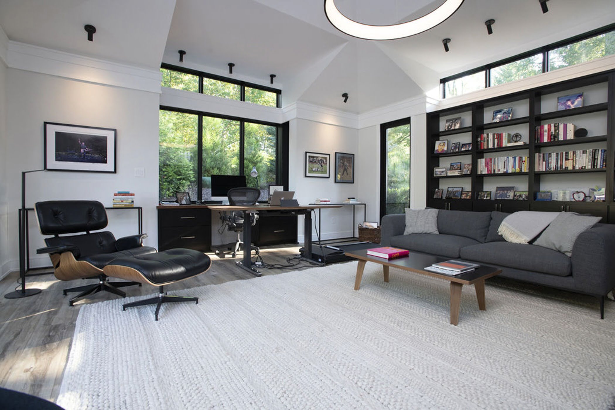 Modern office space with floor to ceiling windows, built in wall shelves and minimalistic furniture