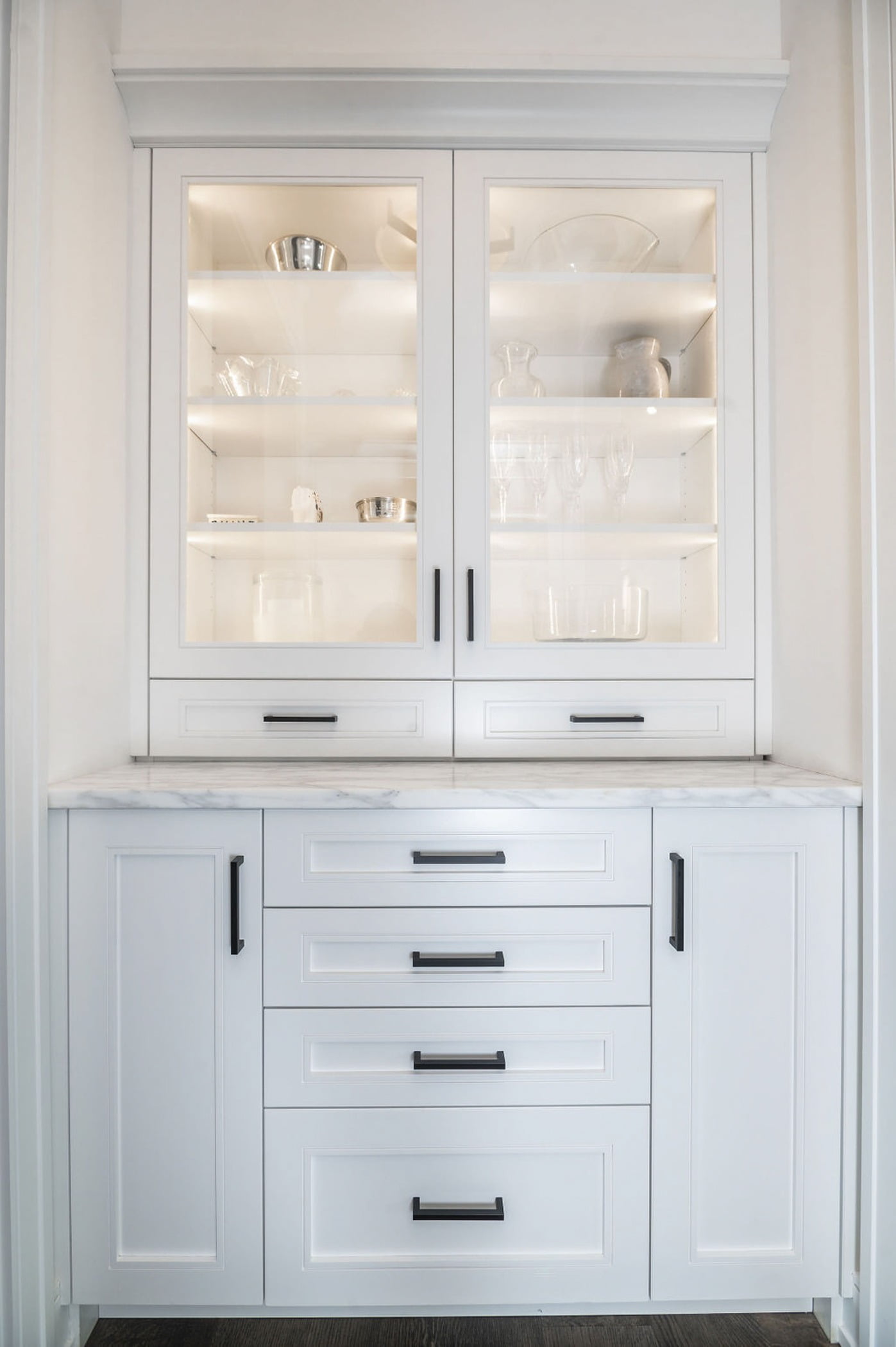 Transitional dining pantry counter with custom white cabinetry and marble countertops