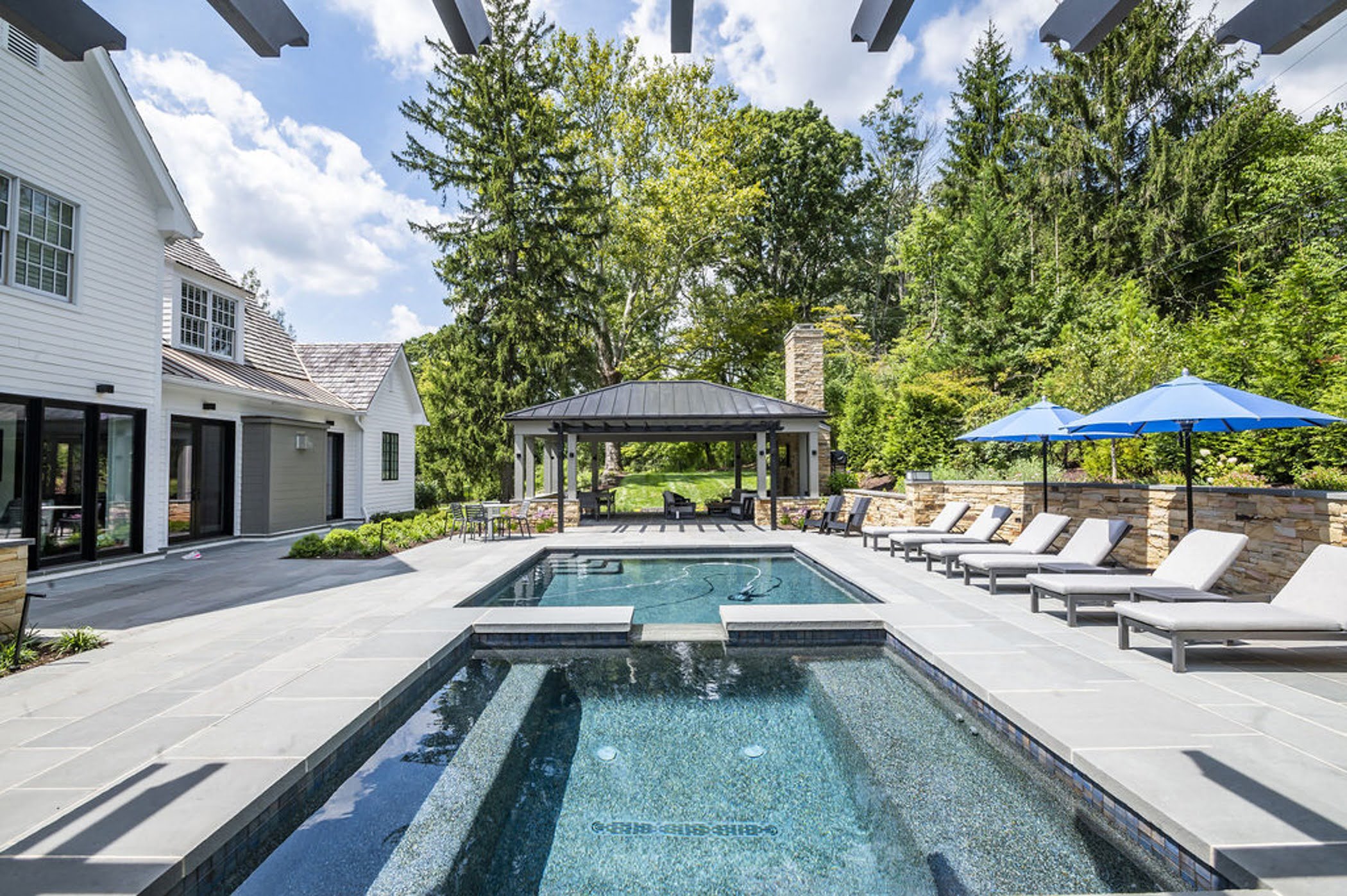 View of Ruxwood pool and patio from under the pool house pergola